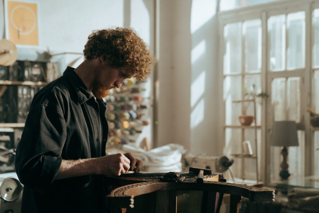 Un homme est penché sur un vieux meuble en bois, et il le répare avec des outils / comment relooker un meuble en bois